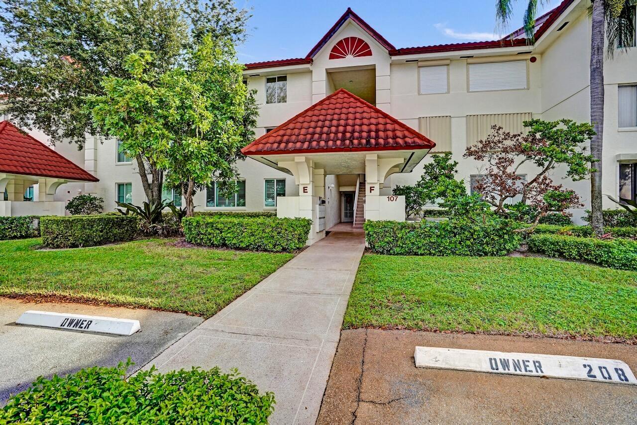 A sidewalk leads to the entrance of a multi-story apartment building with red tile roofs — 107 Half Moon Circle # H1, Hypoluxo FL 33462, HYPOLUXO, FL