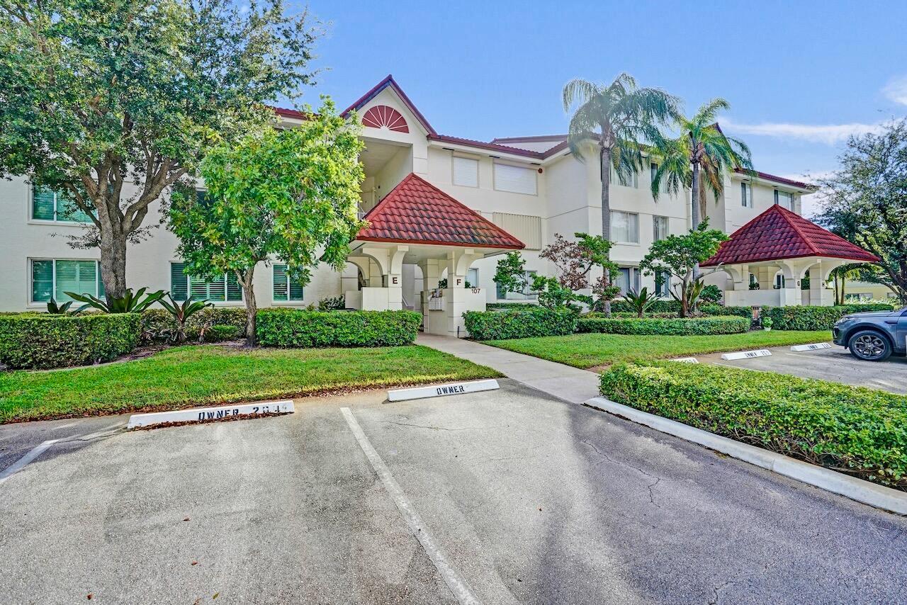 A multi-story apartment building with a red tile roof and designated owner parking spaces — 107 Half Moon Circle # H1, Hypoluxo FL 33462, HYPOLUXO, FL