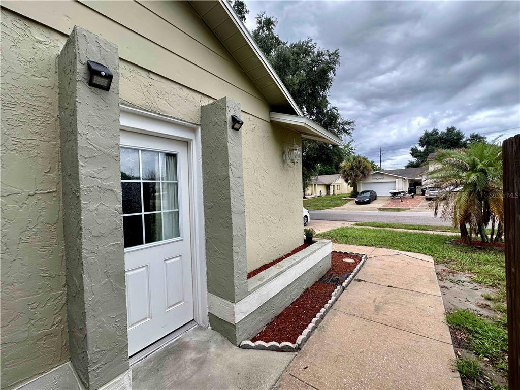 A white door with a glass pane is set between two textured stucco pillars — 7196 HARBOR HEIGHTS CIRCLE UNIT A, ORLANDO, FL