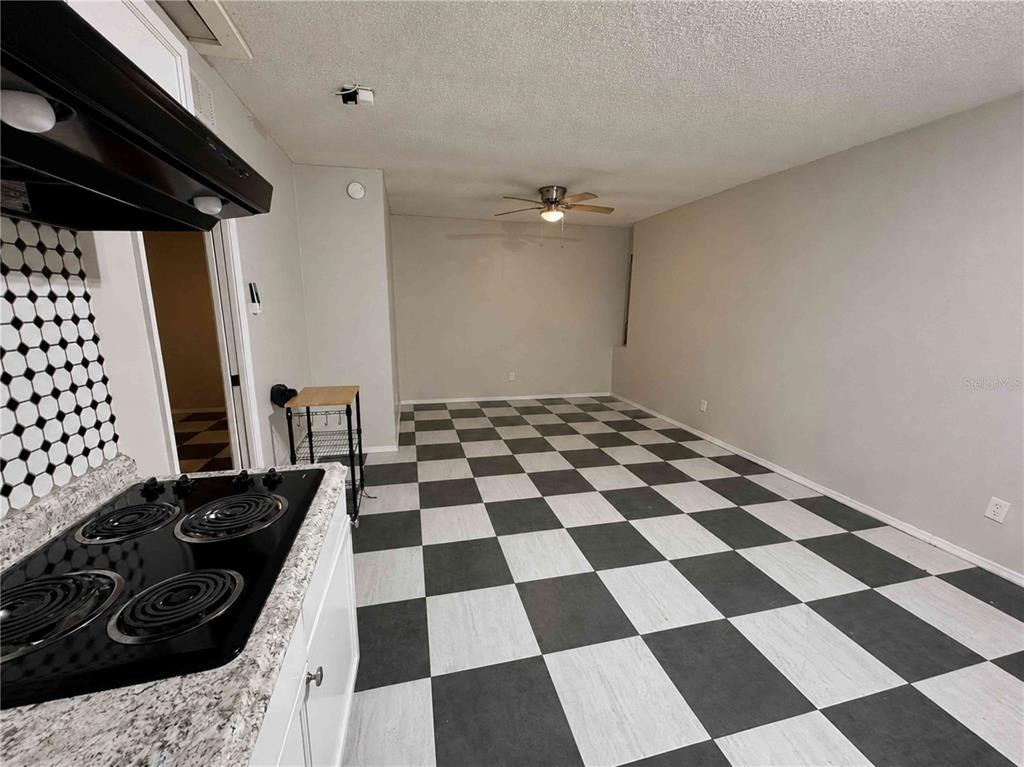 A kitchen and dining area with a black and white checkered floor — 7196 HARBOR HEIGHTS CIRCLE UNIT A, ORLANDO, FL