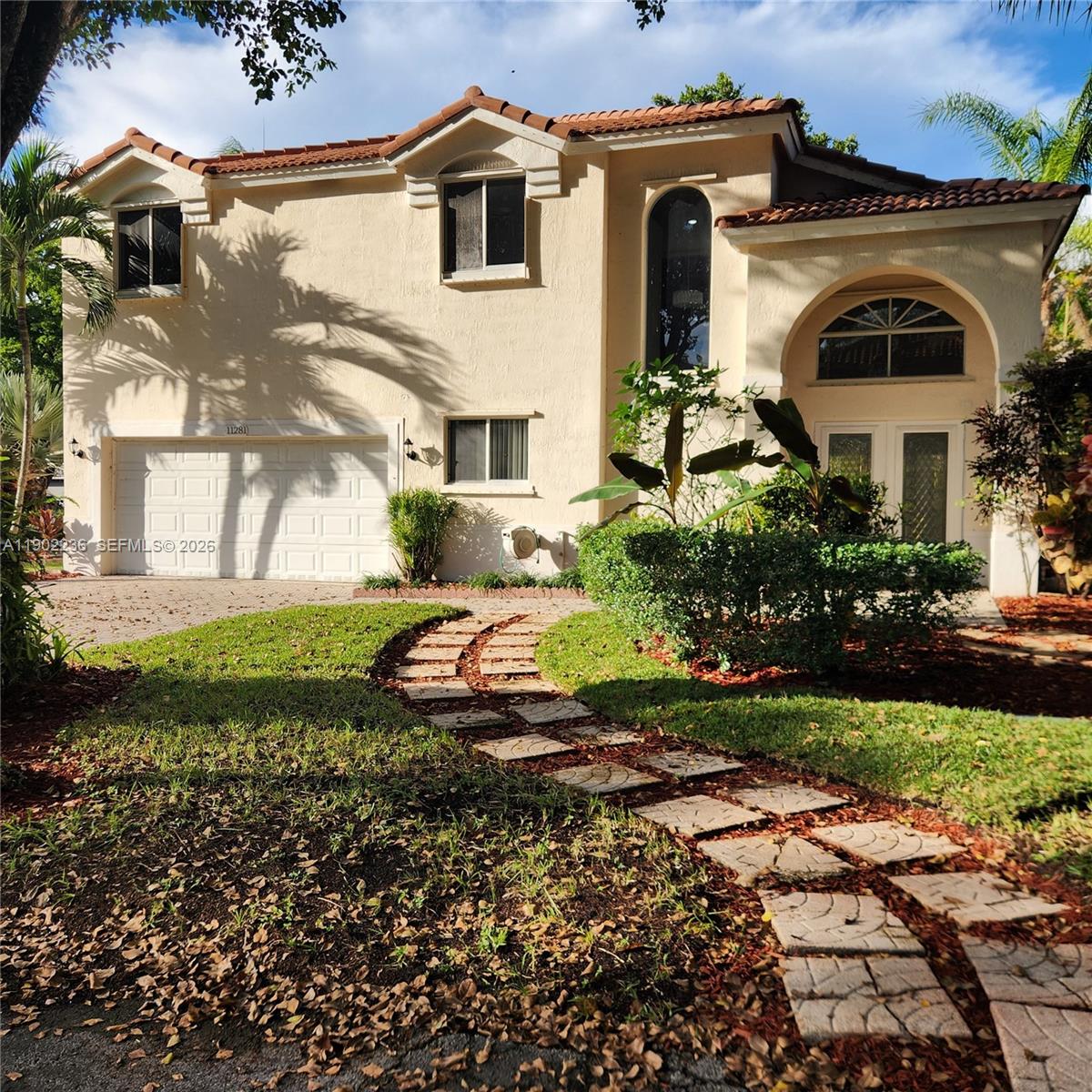 A two-story stucco house with a tile roof, a garage, and a stone walkway — 11281 Reveille Rd, Cooper City FL 33026, COOPER CITY, FL