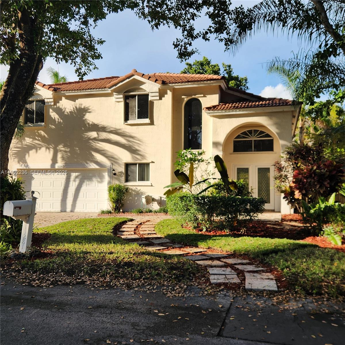 A two-story house with a tiled roof, a garage, and a stone walkway in front — 11281 Reveille Rd, Cooper City FL 33026, COOPER CITY, FL