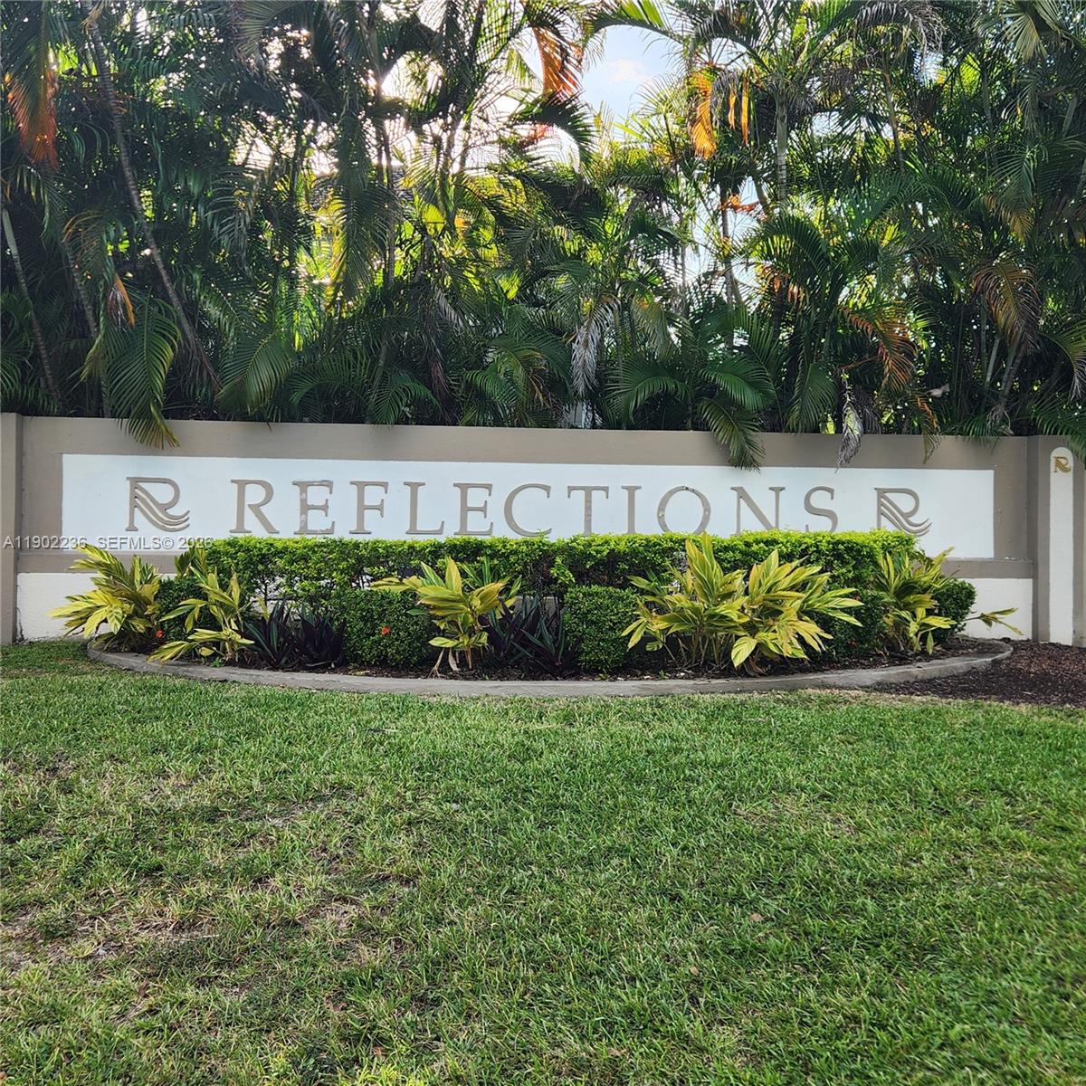 A stone sign for Reflections stands in front of lush palm trees and green landscaping — 11281 Reveille Rd, Cooper City FL 33026, COOPER CITY, FL