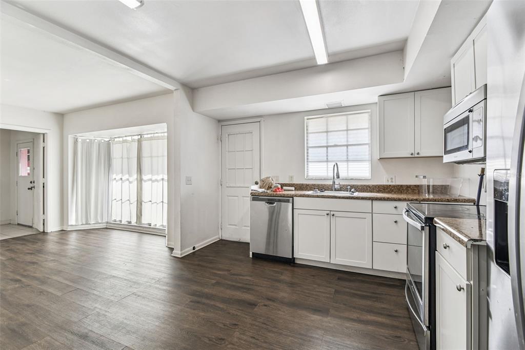 A kitchen with white cabinets, stainless steel appliances, and dark wood-look flooring — 855 E BRANDON BOULEVARD, BRANDON, FL