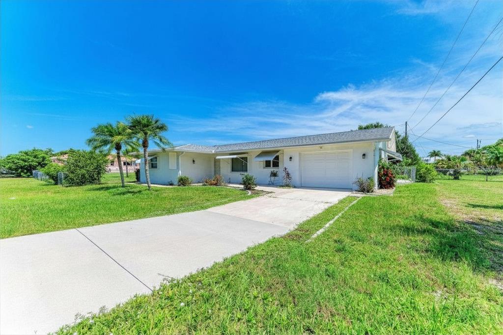 A single-story white house with a concrete driveway and two palm trees in the yard — 20430 EDGEWATER DRIVE, PORT CHARLOTTE, FL