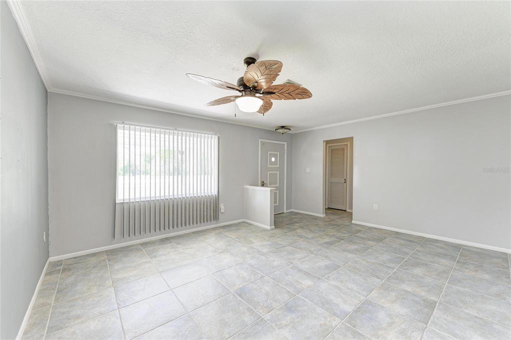 A living room with light gray walls, tile flooring, a ceiling fan, and a window — 20430 EDGEWATER DRIVE, PORT CHARLOTTE, FL