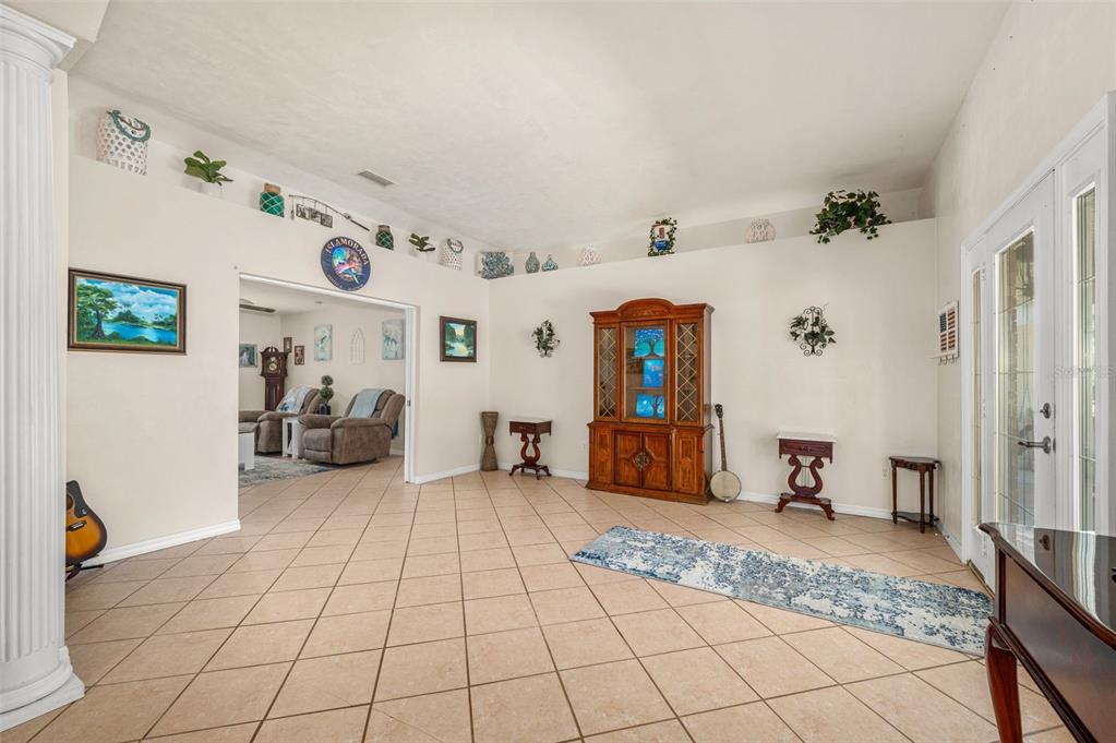 A spacious living area with tile flooring, a wooden hutch, and a vaulted ceiling — 6459 SE COUNTY ROAD 337, NEWBERRY, FL