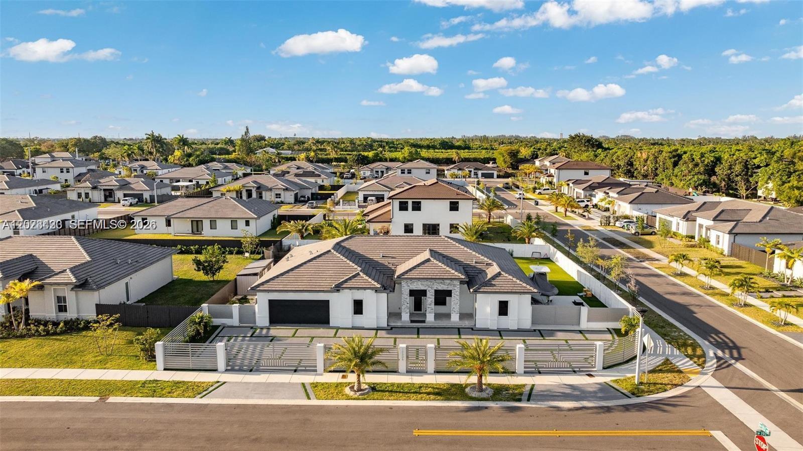 An aerial view shows a modern single-story house with a tiled roof and gated driveway — 13305 SW 190th Ter # 13305, Miami FL 33177, MIAMI, FL