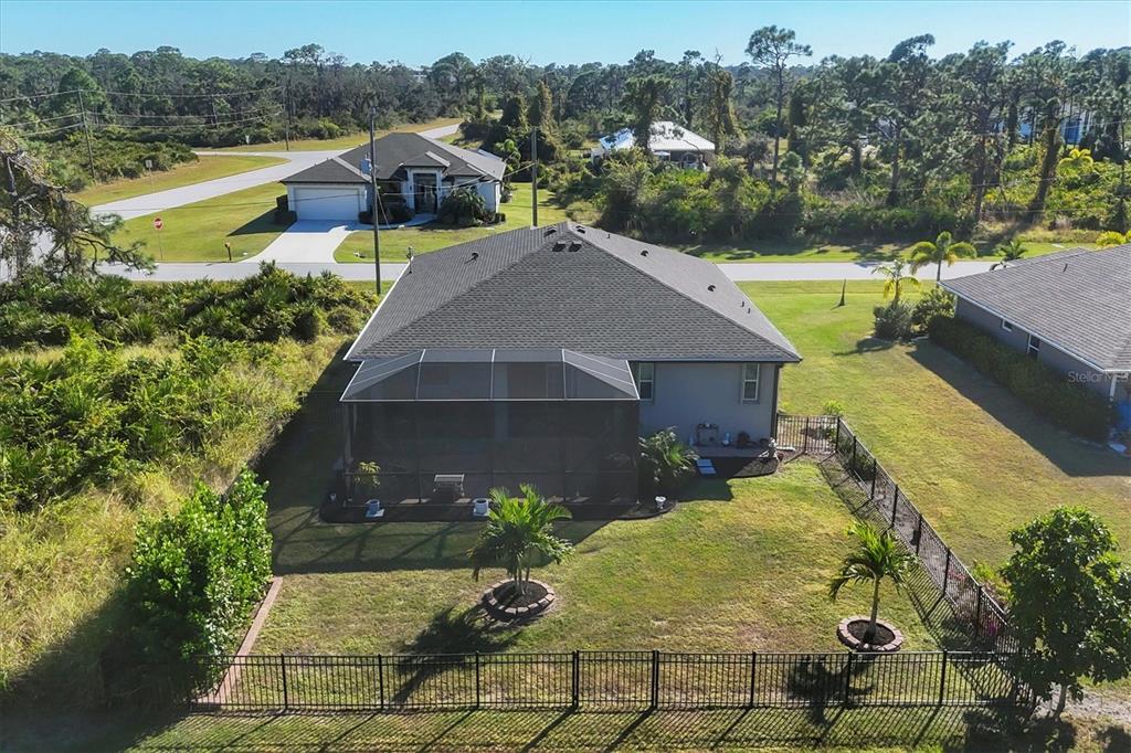 An aerial view shows a single-story house with a screened-in lanai and fenced backyard — 112 BERYL DRIVE, ROTONDA WEST, FL