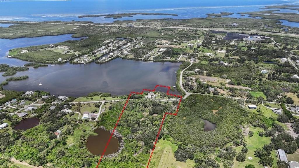 An aerial view shows a waterfront property outlined in red, surrounded by trees and water — 1470 BAYSHORE DRIVE, TERRA CEIA, FL