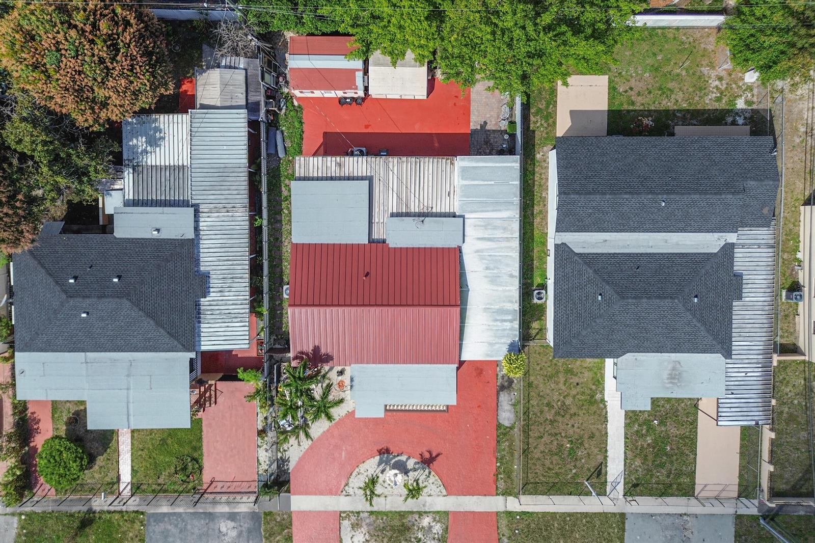 An aerial view shows three adjacent houses with red-paved driveways and metal roof sections — 4970 E Palm Court, Hialeah FL 33013, HIALEAH, FL