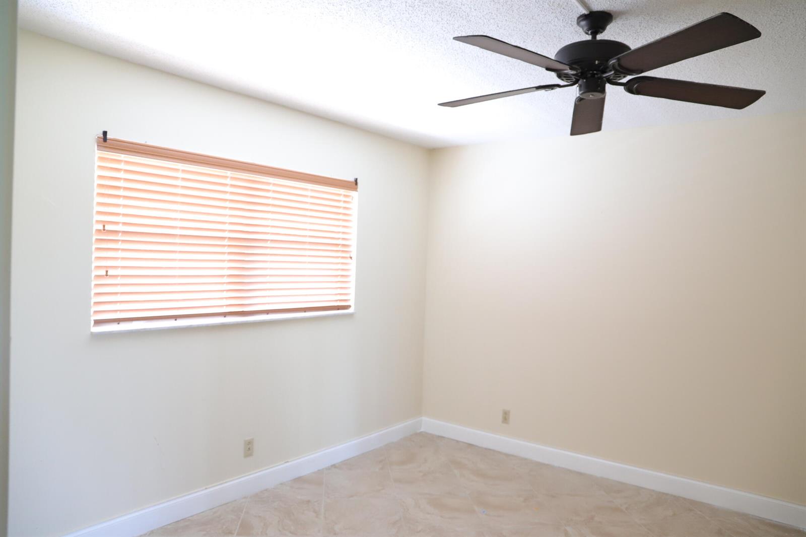 An empty room with beige walls, tile flooring, a ceiling fan, and a window with blinds — 6400 NW 2nd Avenue # 423, Boca Raton FL 33487, BOCA RATON, FL