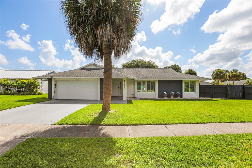 A living room features light tile floors, a recessed ceiling, and a red chandelier — 10539 WOODWAY DRIVE, ORLANDO, FL
