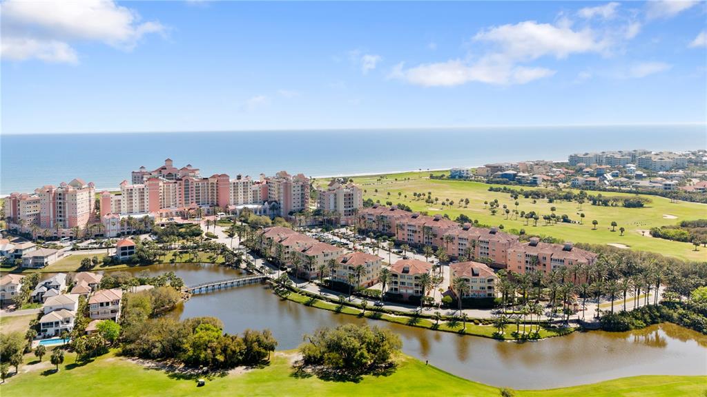 An aerial view shows a large resort complex with multiple buildings, a lake, and golf course — 15 OCEAN CREST WAY UNIT 1324, PALM COAST, FL