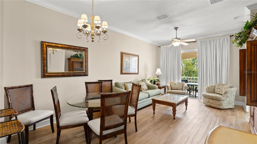 This living and dining area features a glass-top table, light-colored furniture, and wood-look flooring — 15 OCEAN CREST WAY UNIT 1324, PALM COAST, FL