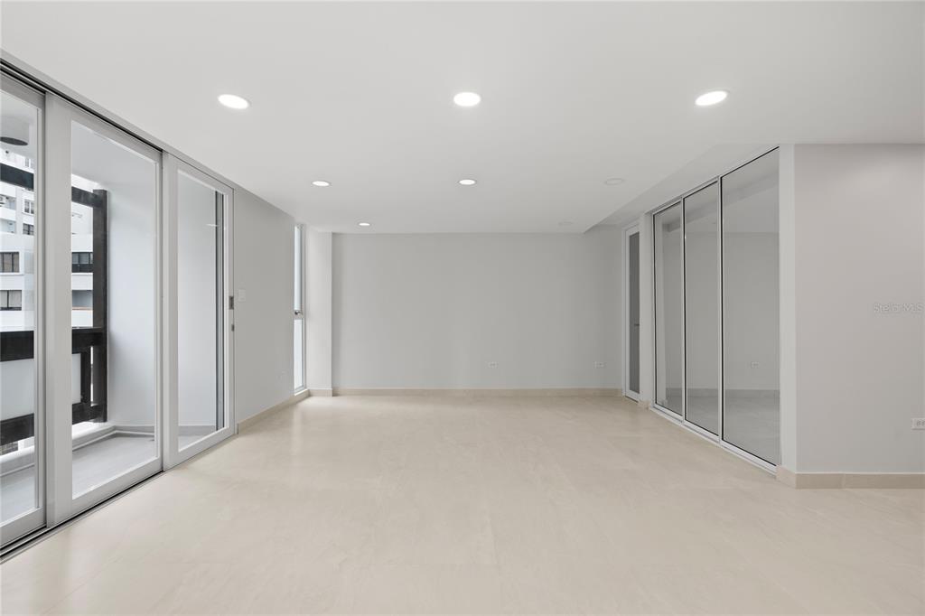 An empty room with light tile floors, recessed lighting, and large glass sliding doors — 1407 ASHFORD AVENUE UNIT 5D, SAN JUAN, PR