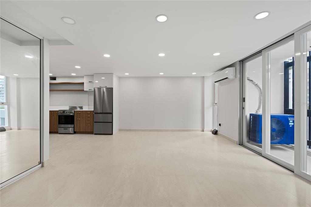 A modern, open-concept kitchen and living area with light tile flooring and recessed lighting — 1407 ASHFORD AVENUE UNIT 5D, SAN JUAN, PR