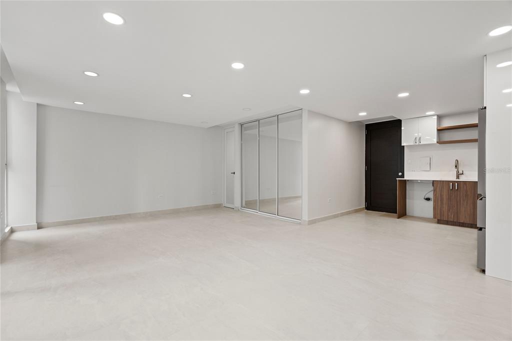 An open-concept room features light tile flooring, recessed lighting, mirrored closet doors, and a kitchenette — 1407 ASHFORD AVENUE UNIT 5D, SAN JUAN, PR