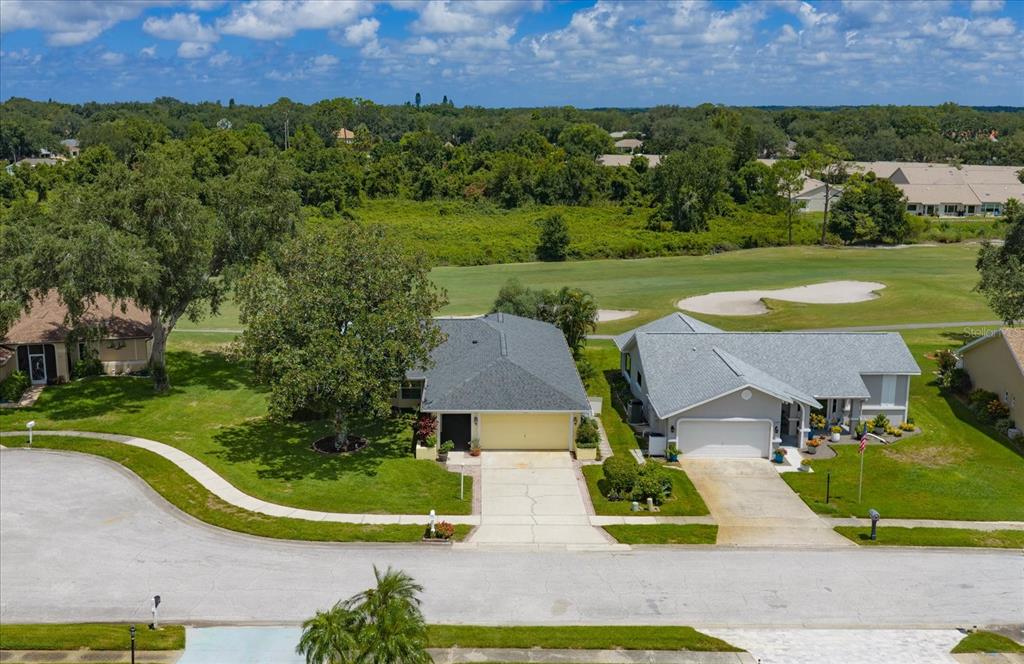 An aerial view shows a suburban neighborhood with houses bordering a golf course — 3495 W LINKS COURT, PALM HARBOR, FL