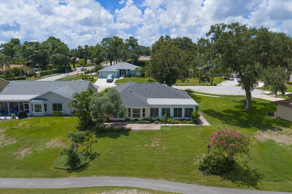 An aerial view shows two suburban houses with driveways facing a street and a golf course — 3495 W LINKS COURT, PALM HARBOR, FL