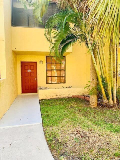 A yellow two-story building exterior features a red front door and a palm tree — 793 SE 1st Way # 73, Deerfield Beach FL 33441, DEERFIELD BEACH, FL