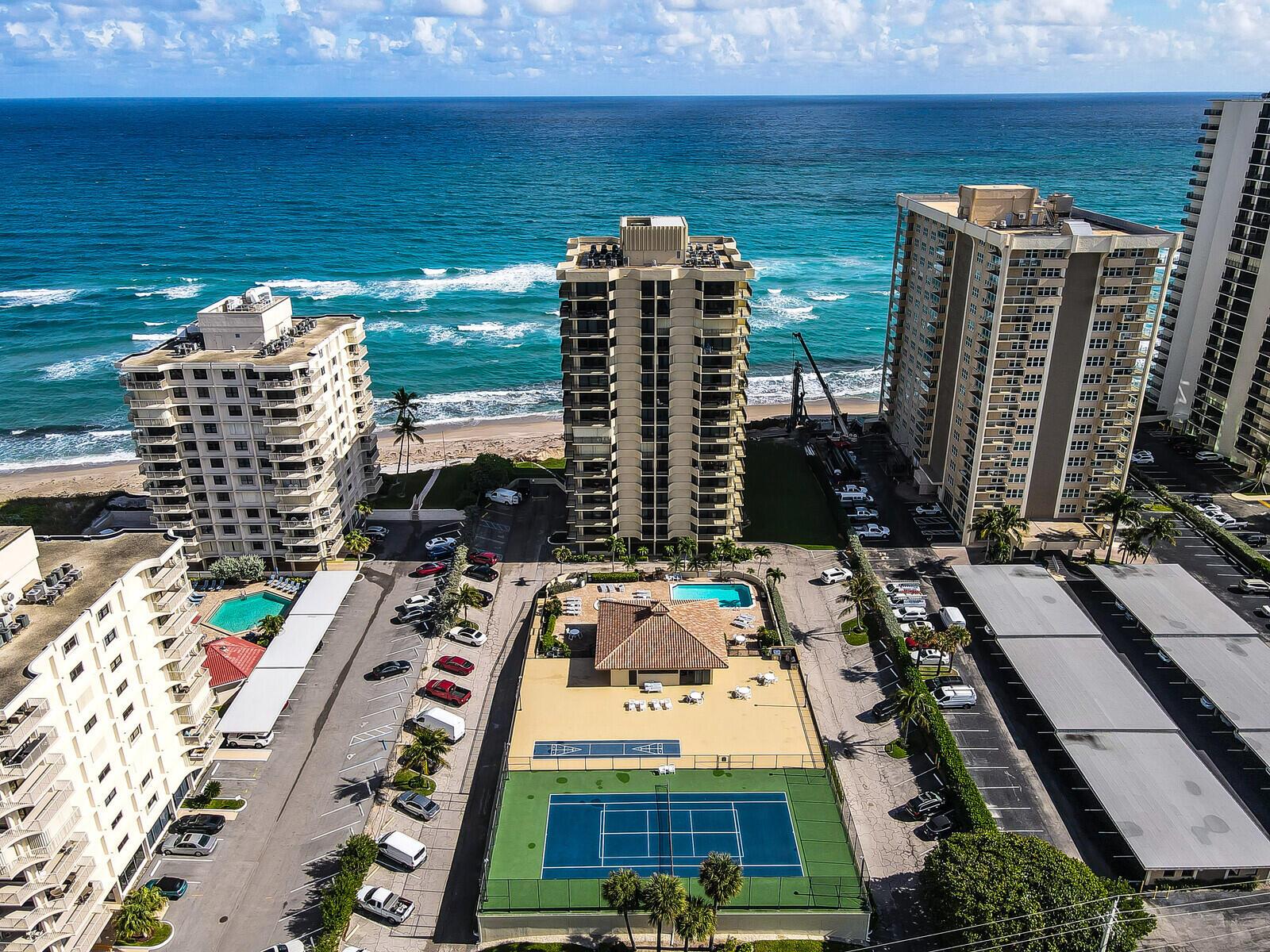 An aerial view of high-rise beachfront condominiums with a swimming pool and tennis court — 5460 N Ocean Drive # 1d, Singer Island FL 33404, SINGER ISLAND, FL