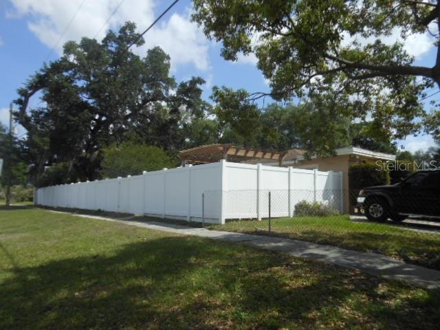 A white vinyl privacy fence surrounds the backyard of a house with a wooden pergola — 2925 W PARIS STREET, TAMPA, FL