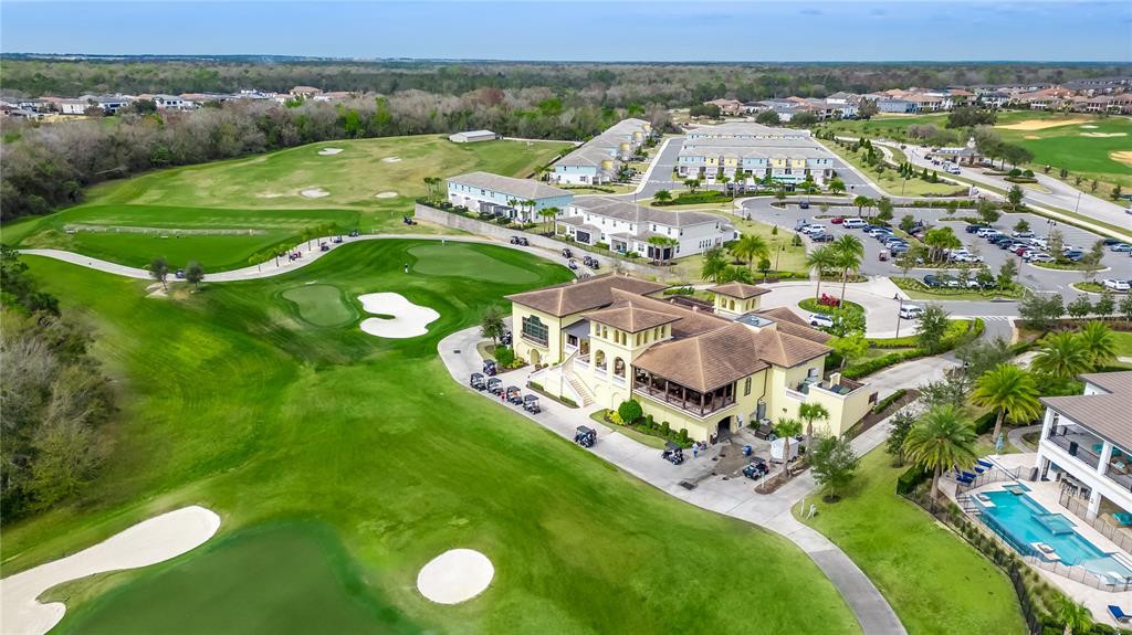 An aerial view shows a golf course clubhouse, surrounding residential buildings, and a swimming pool — 7909 DRAW STREET, REUNION, FL