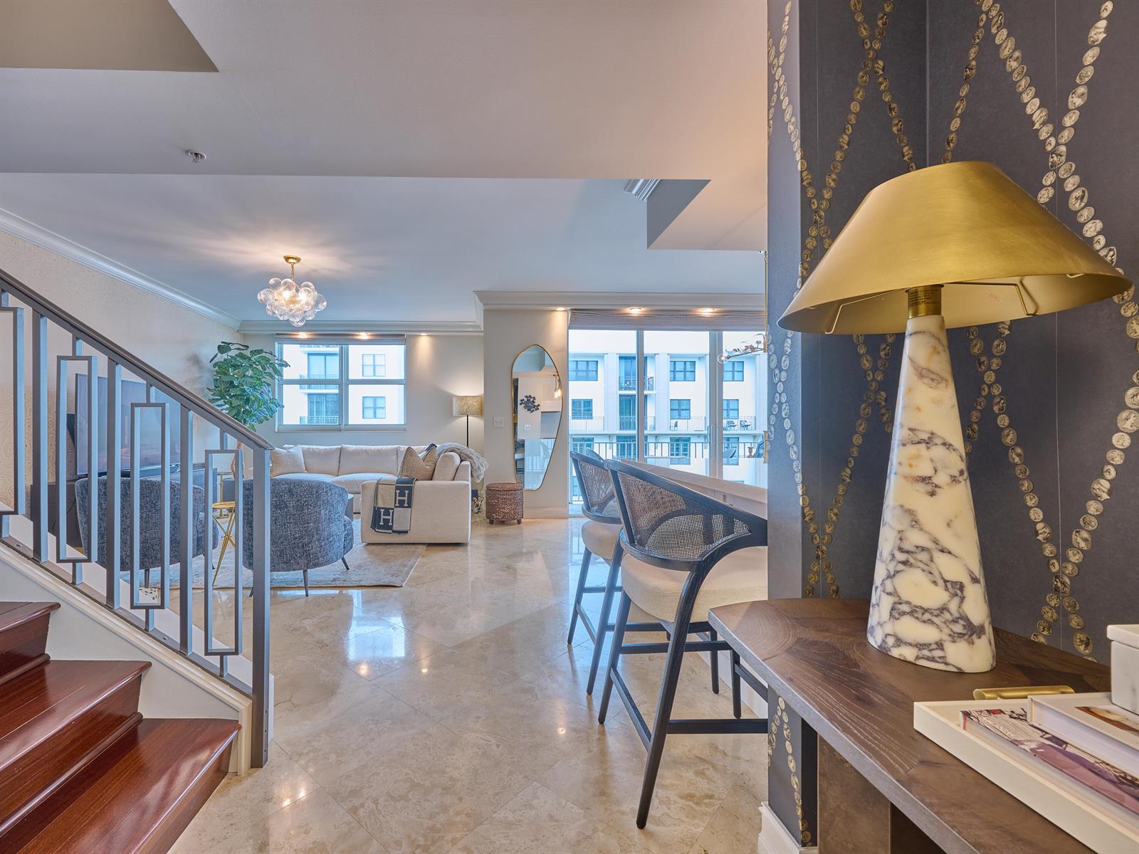 A view from a staircase looking into a living room with marble floors and furniture — 99 SE Mizner Boulevard # 35, Boca Raton FL 33432, BOCA RATON, FL
