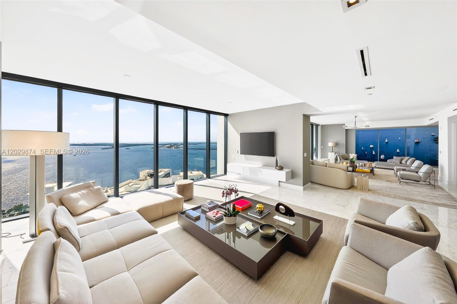 A modern living room features floor-to-ceiling windows with expansive water views and marble flooring — 1451 Brickell Ave # 2901, Miami FL 33131, MIAMI, FL