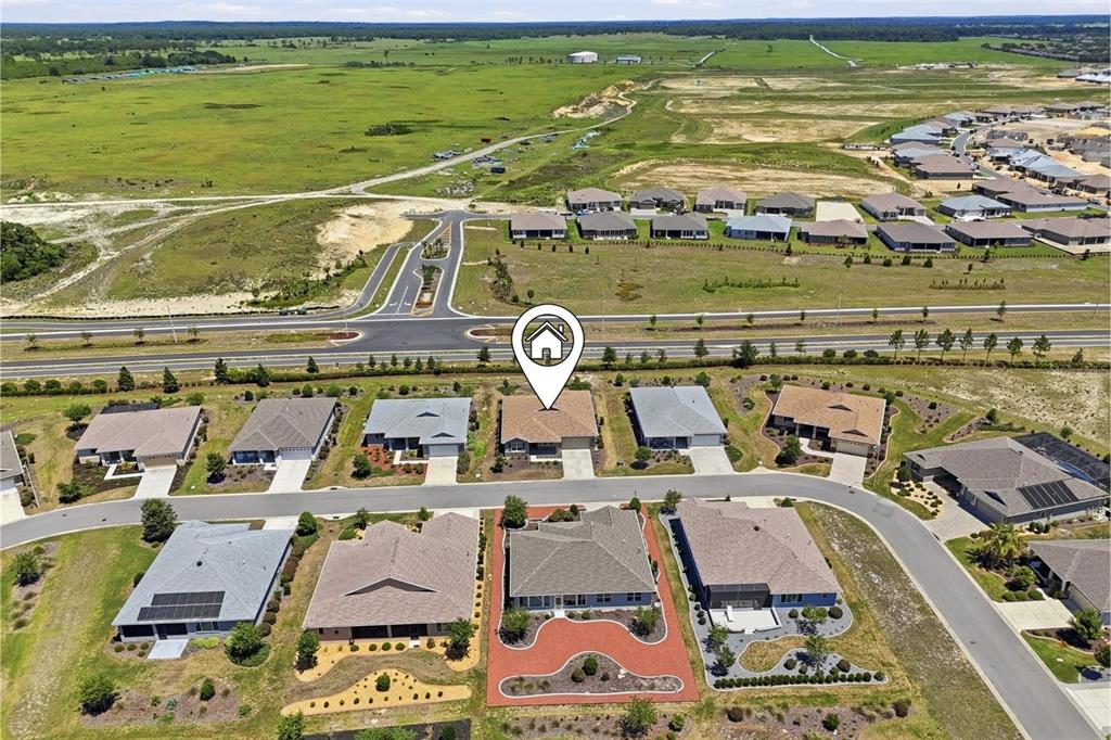 An aerial view shows a suburban neighborhood with single-family homes and surrounding undeveloped land — 8907 SW 104TH CIRCLE, OCALA, FL