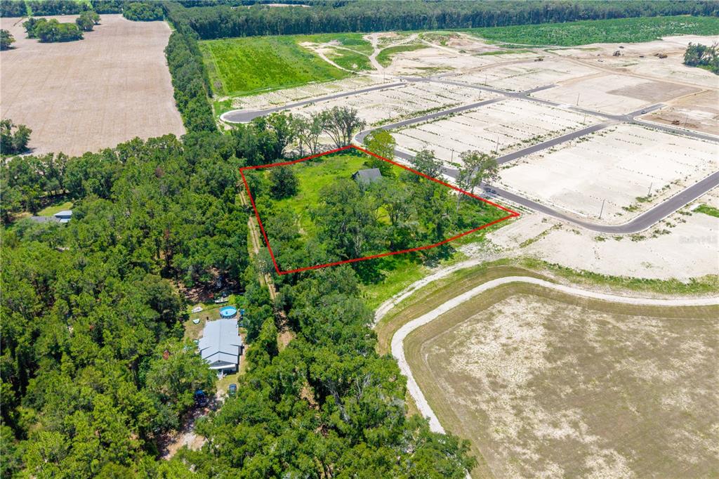 An aerial view shows a rectangular lot outlined in red, surrounded by trees and development — 23479 W NEWBERRY ROAD, NEWBERRY, FL