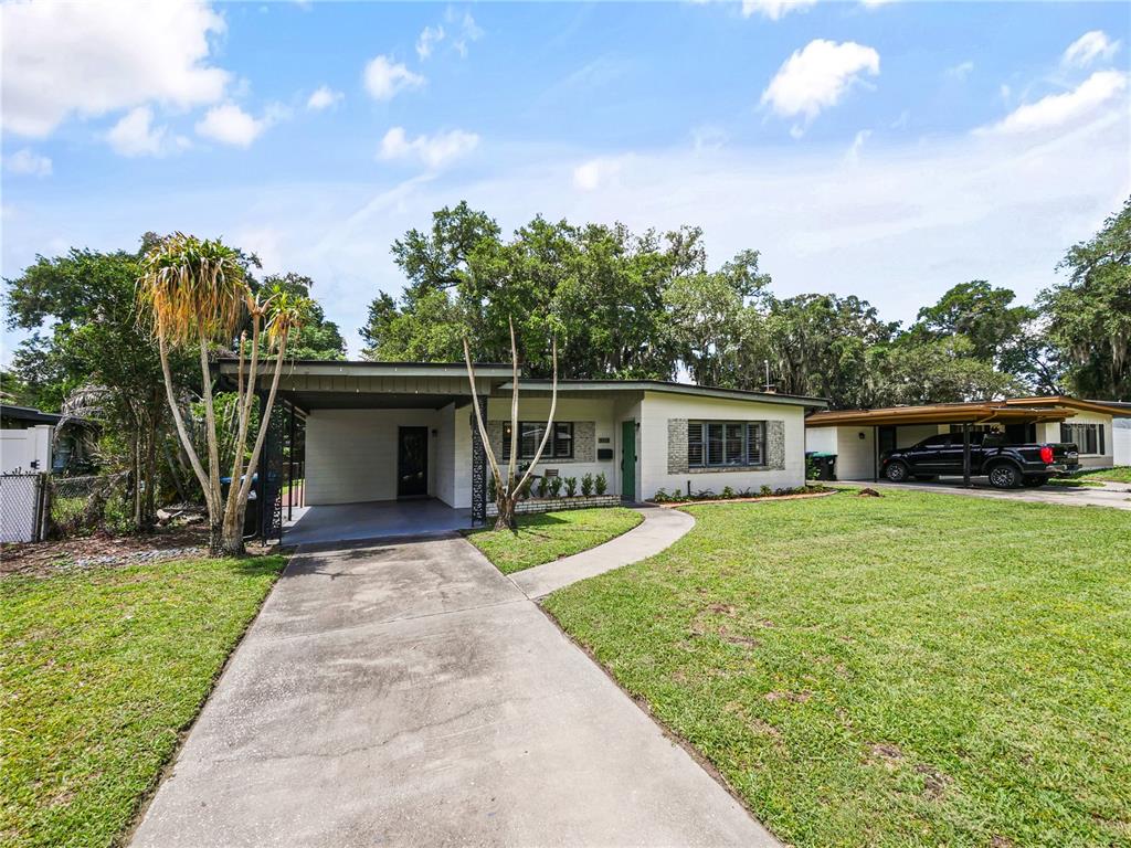 A single-story house with a carport, concrete driveway, and a large front lawn — 3112 ILLINGWORTH AVENUE, ORLANDO, FL