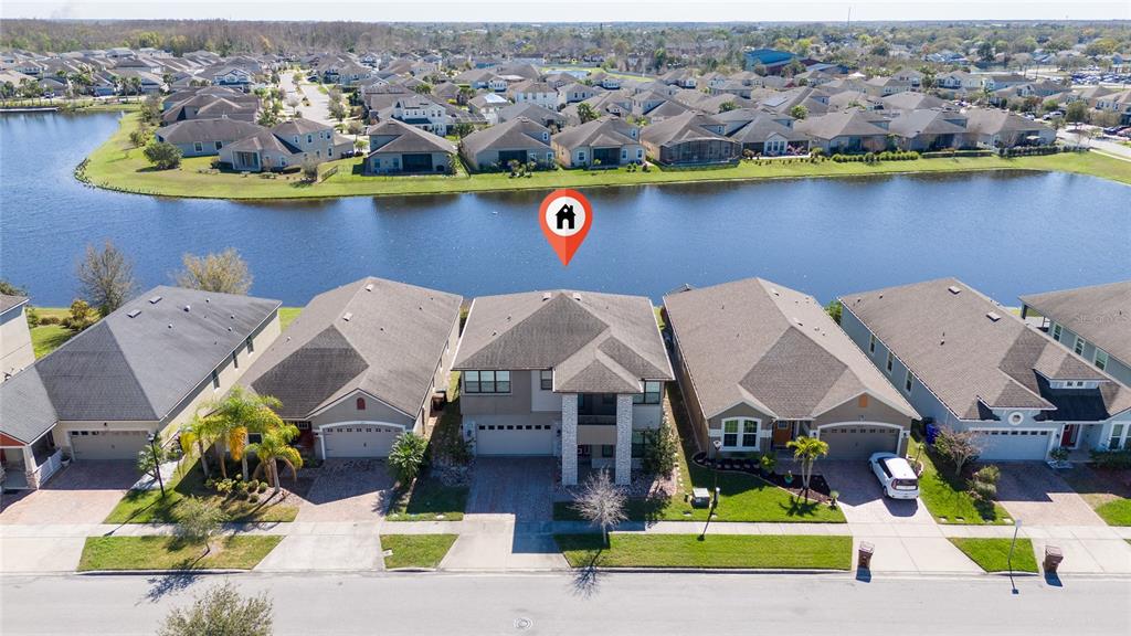 An aerial view shows a row of suburban houses situated along a waterfront — 3018 JARDIN STREET, KISSIMMEE, FL