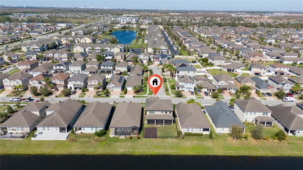 An aerial view shows a residential neighborhood with a marked house facing a small lake — 3018 JARDIN STREET, KISSIMMEE, FL