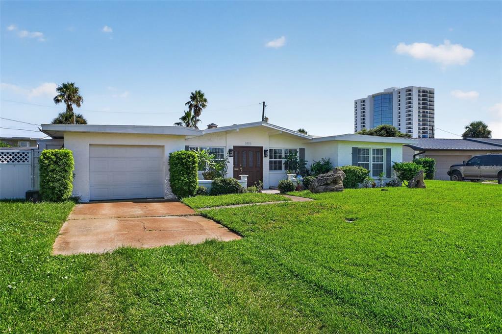 A single-story house with a white exterior, a garage, and a large front lawn — 2525 CORAL WAY W, DAYTONA BEACH, FL
