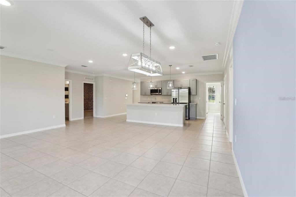 A spacious open-concept kitchen features gray cabinetry, stainless steel appliances, and a large island — 2410 PARK AVENUE, INDIAN LAKE ESTATES, FL