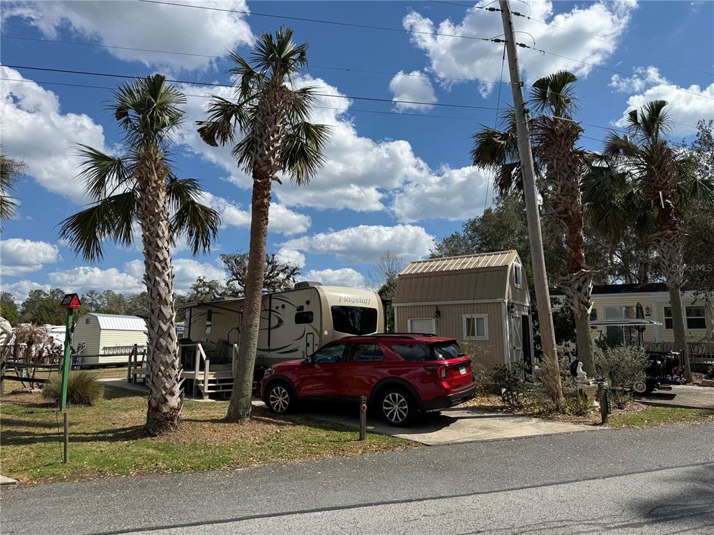A red SUV is parked next to a Flagstaff travel trailer and a storage shed — 2875 NE 102ND AVENUE ROAD, SILVER SPRINGS, FL