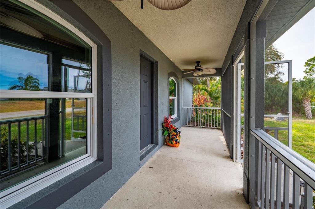 A covered, screened-in porch features gray stucco walls, a ceiling fan, and a concrete floor — 5250 SUNNYVALE ROAD, NORTH PORT, FL