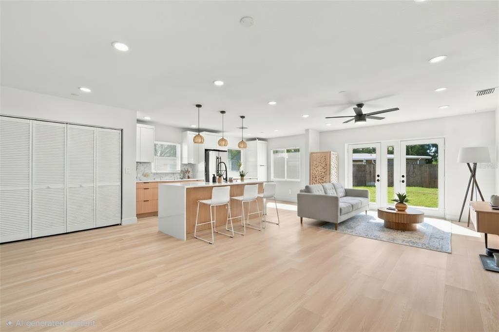 This open-concept living area features a modern kitchen with a slatted island and light flooring — 7017 20TH STREET N, ST PETERSBURG, FL