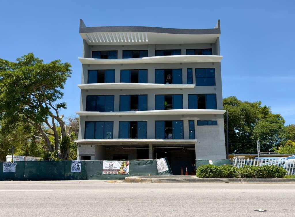 A four-story modern building under construction features curved white balconies and dark-framed windows — 4110 NW 22nd Avenue # 1, Miami FL 33142, MIAMI, FL