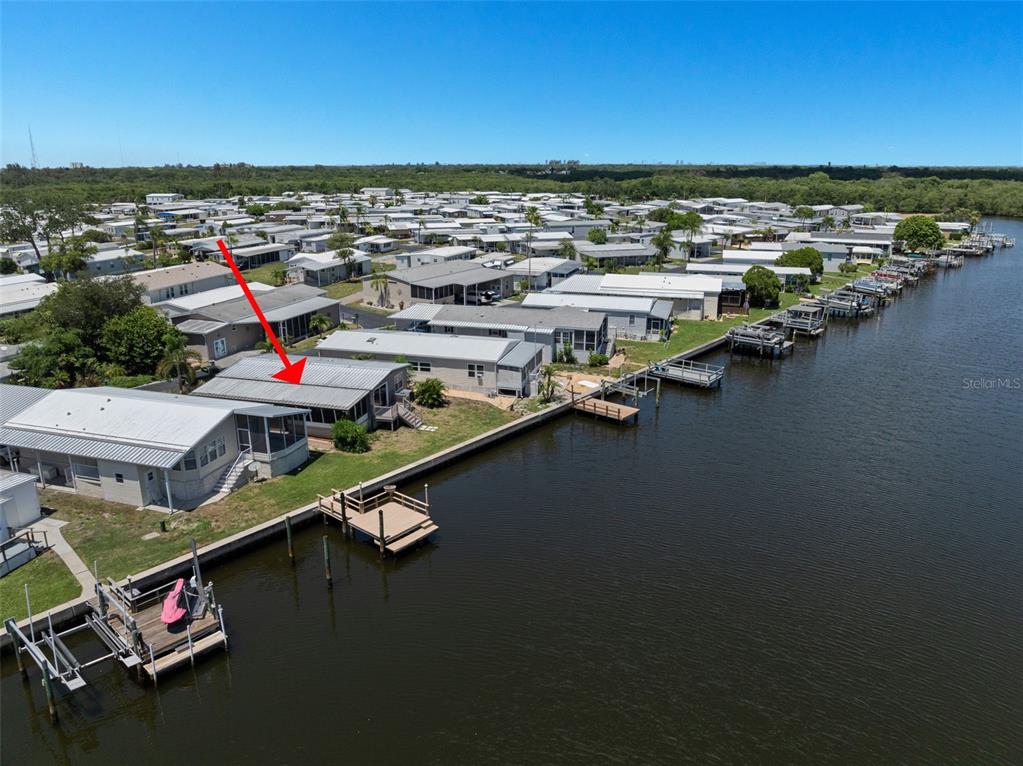 An aerial view shows a waterfront mobile home with a private dock and boat lift — 460 MOUNT OAK AVENUE NE UNIT 745, ST PETERSBURG, FL