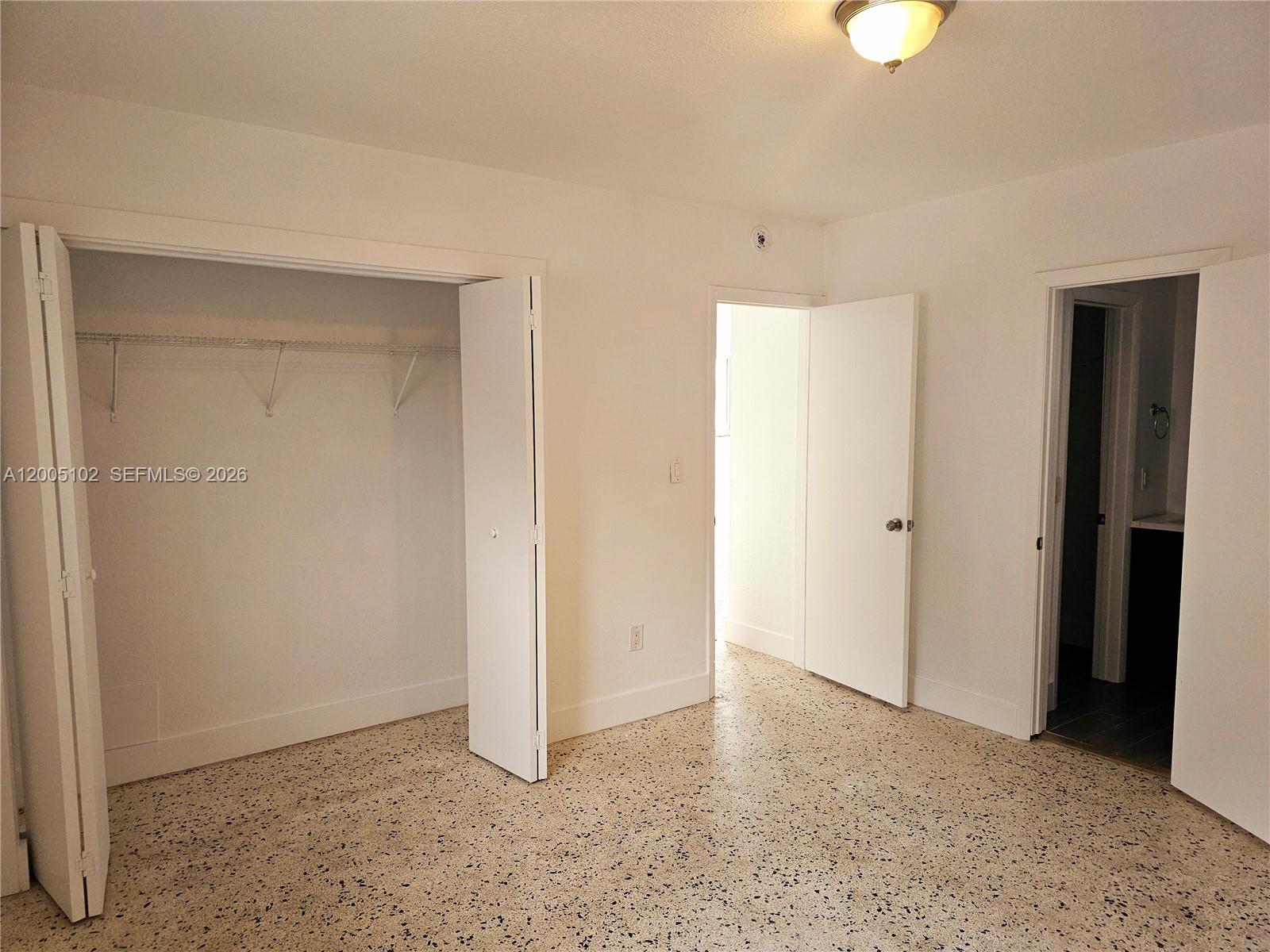 A room with white walls, a closet, two doorways, and speckled flooring — 1736 SW 3rd St # 3, Miami FL 33135, MIAMI, FL