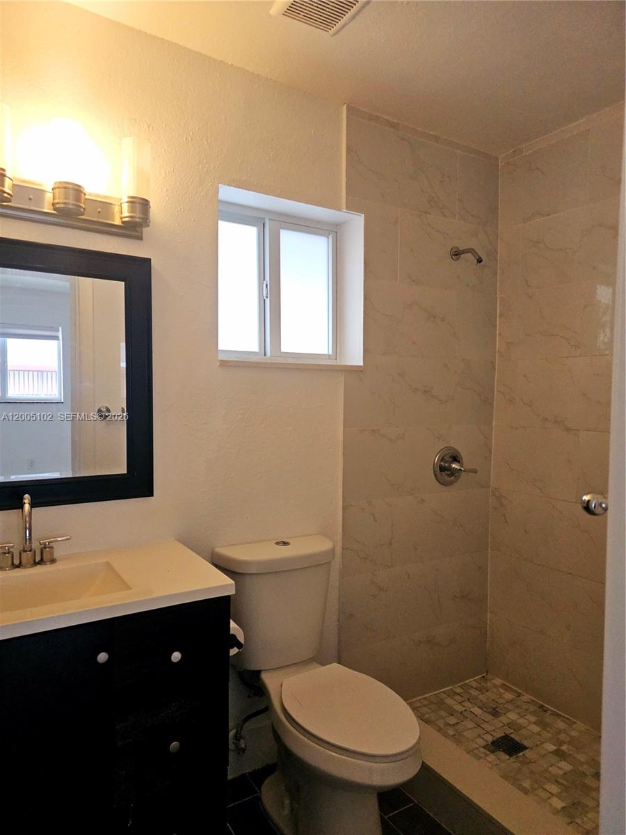 A bathroom features a black vanity, a white toilet, and a tiled walk-in shower — 1736 SW 3rd St # 3, Miami FL 33135, MIAMI, FL