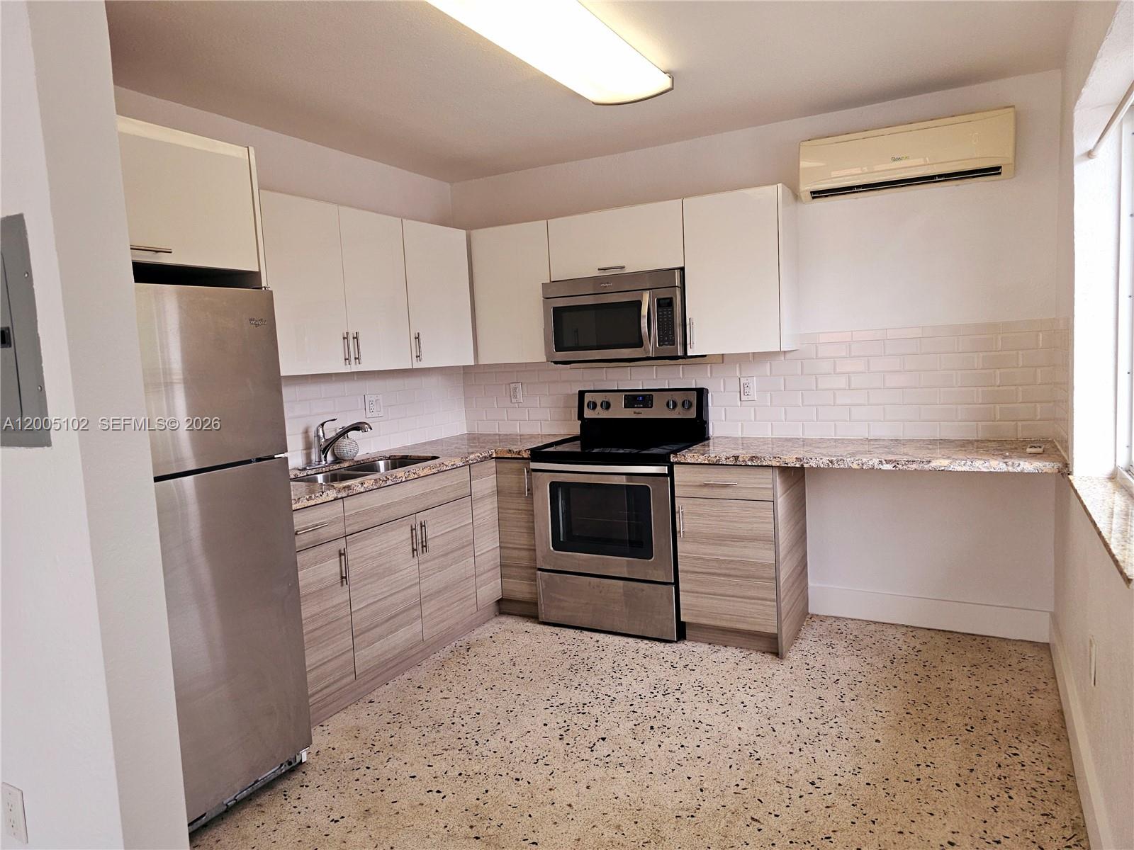 A kitchen features stainless steel appliances, wood-grain lower cabinets, white upper cabinets, and granite countertops — 1736 SW 3rd St # 3, Miami FL 33135, MIAMI, FL