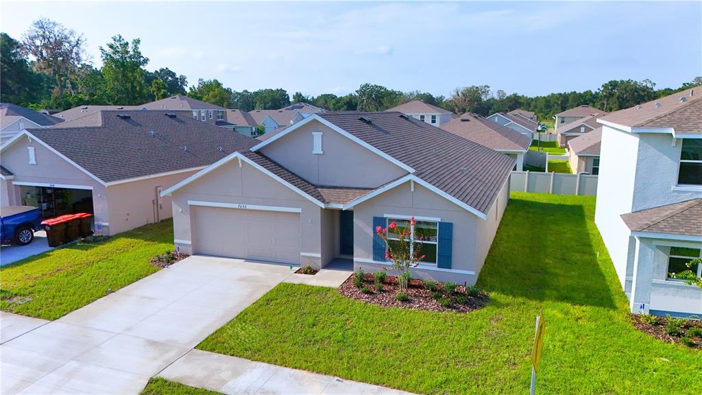An aerial view shows a single-story suburban house with a two-car garage and lawn — 7230 SE 112TH LANE, BELLEVIEW, FL