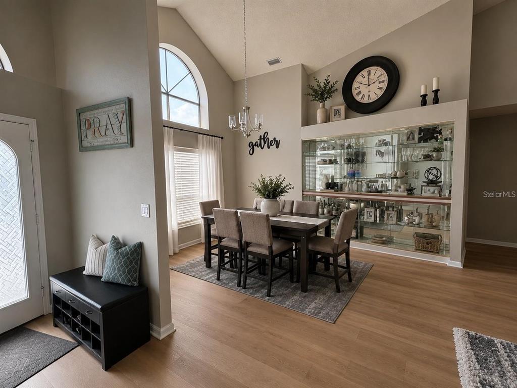 A dining room with a wooden table, chairs, a chandelier, and a large built-in display cabinet — 18561 WINDING OAKS BOULEVARD, HUDSON, FL