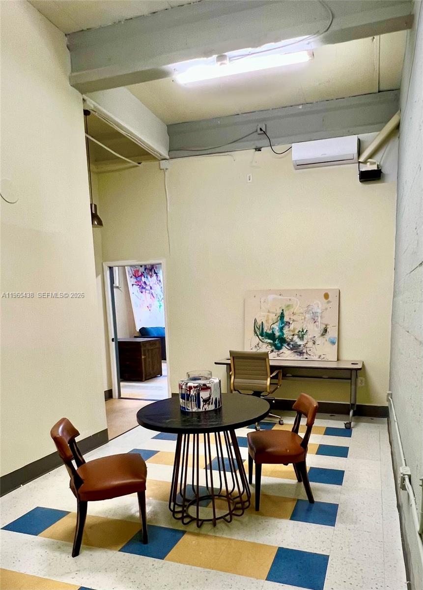 A room features a round table with two chairs, a desk, and a patterned floor — 3257 NW 7 Ave Cir # A, Miami FL 33127, MIAMI, FL