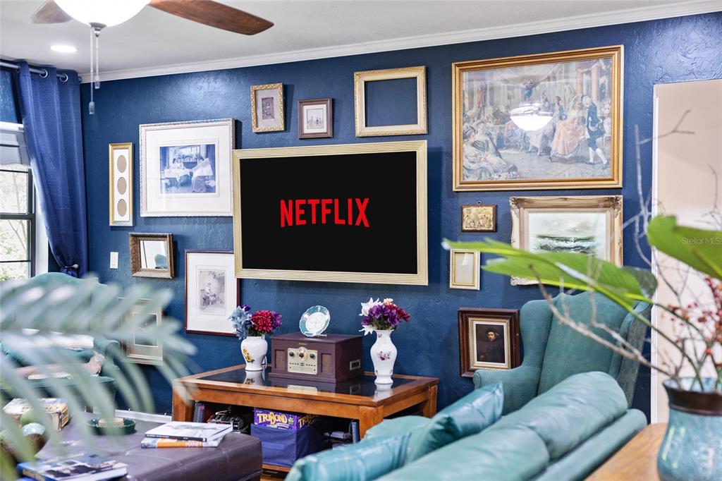 A living room features a dark blue accent wall decorated with a gallery of framed art — 9800 SW 190TH TERRACE ROAD, DUNNELLON, FL