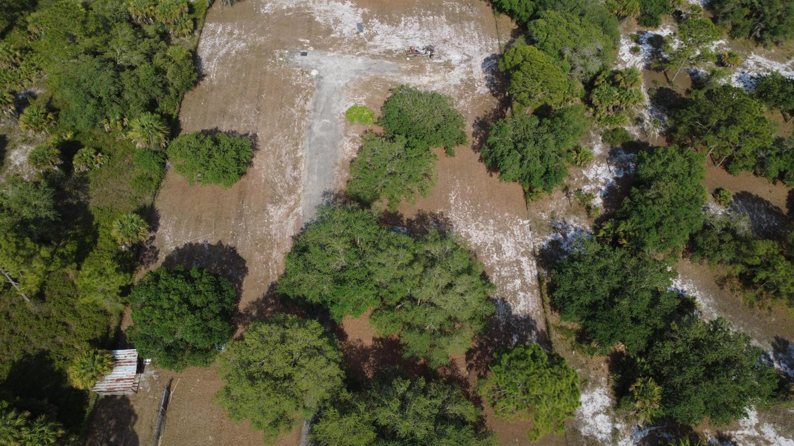 An aerial view shows a cleared dirt lot with scattered trees and a small structure — 825 S Verda Street, Clewiston FL 33440, CLEWISTON, FL